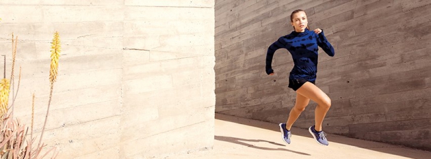 Frau rennend in blau-schwarzer adidas-Bekleidung