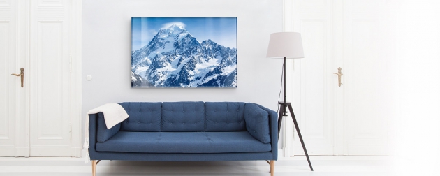 Bild mit Bergen an der Wand und davor eine blaue Couch