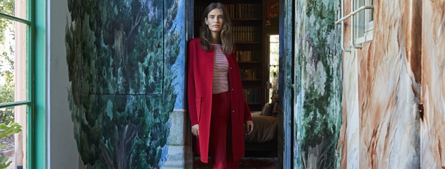 Frau in rot gekleidet in der Tür stehend